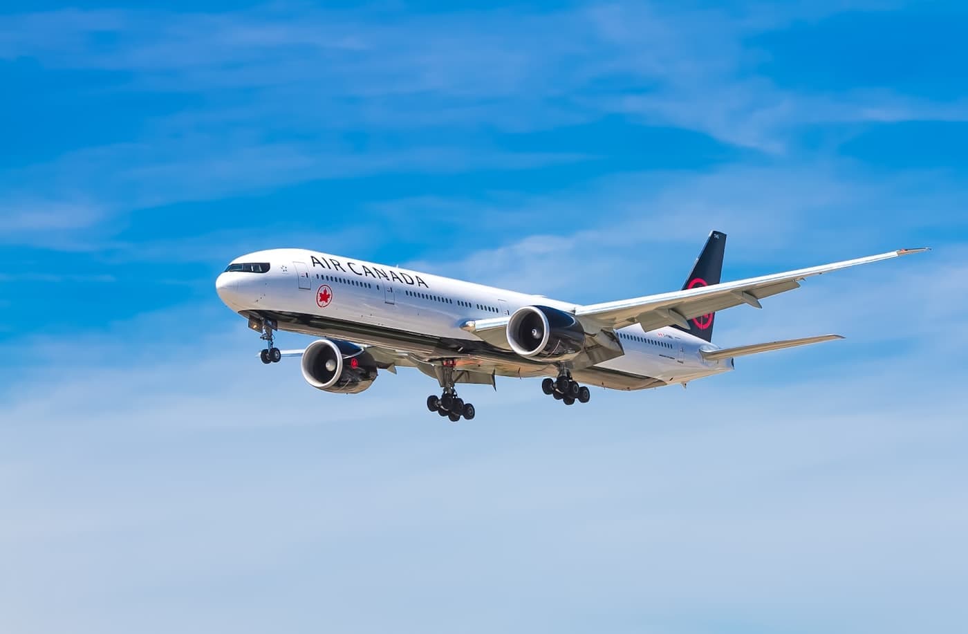 Air Canada Boeing 777-300ER on final approach against a blue sky