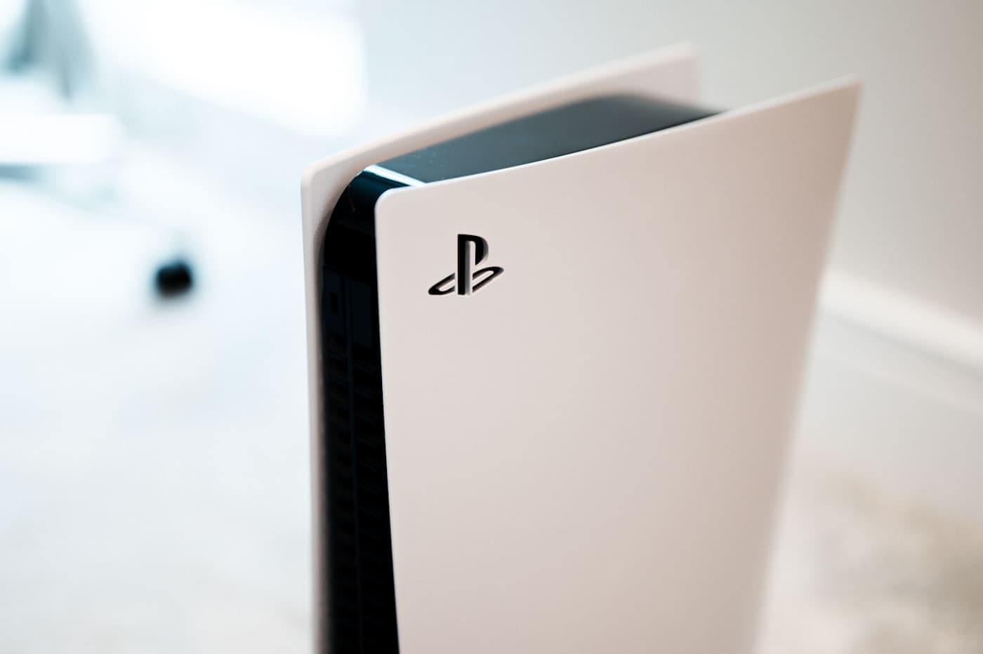 White PlayStation 5 console standing upright, PlayStation logo visible